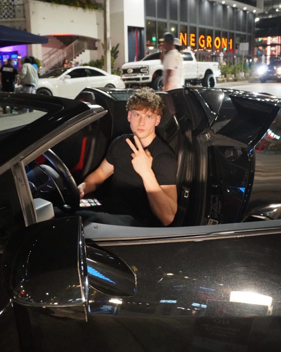 Collin Christiansen seated in a convertible at night